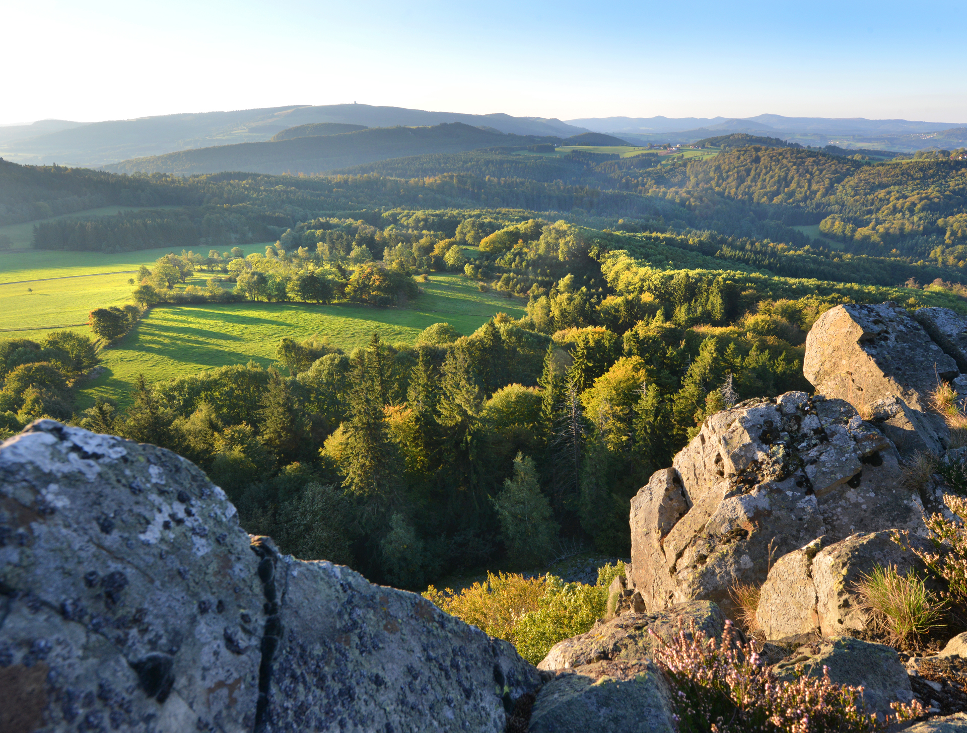 Blick von der felsigen Landschaft hinüber zum runden Radom der Wasserkuppe.
