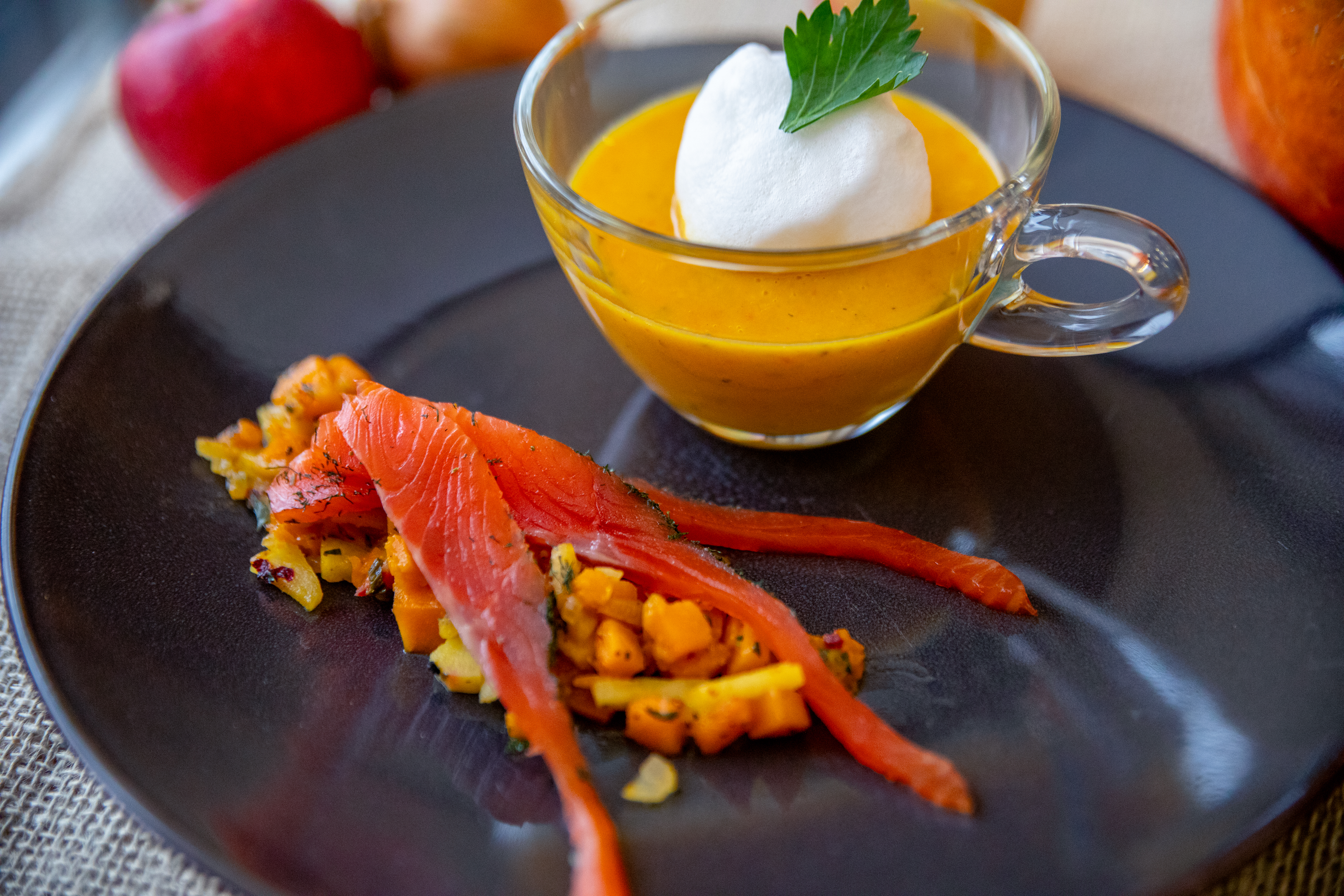 Aufgeschäumter Kürbis-Apfel-Cappuccino mit Kürbis-Chutney und lauwarm geräuchertem Lachsforellenfilet.