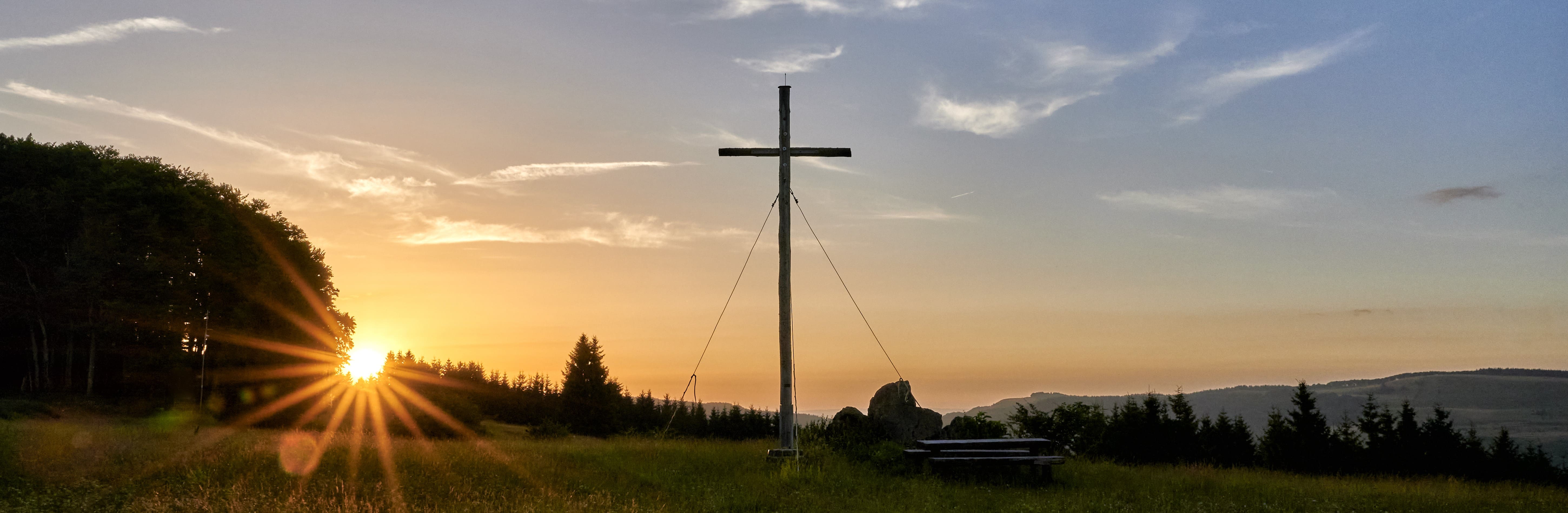 Das Gipfelkreuz auf dem Arnsberg bei Sonnenaufgang.