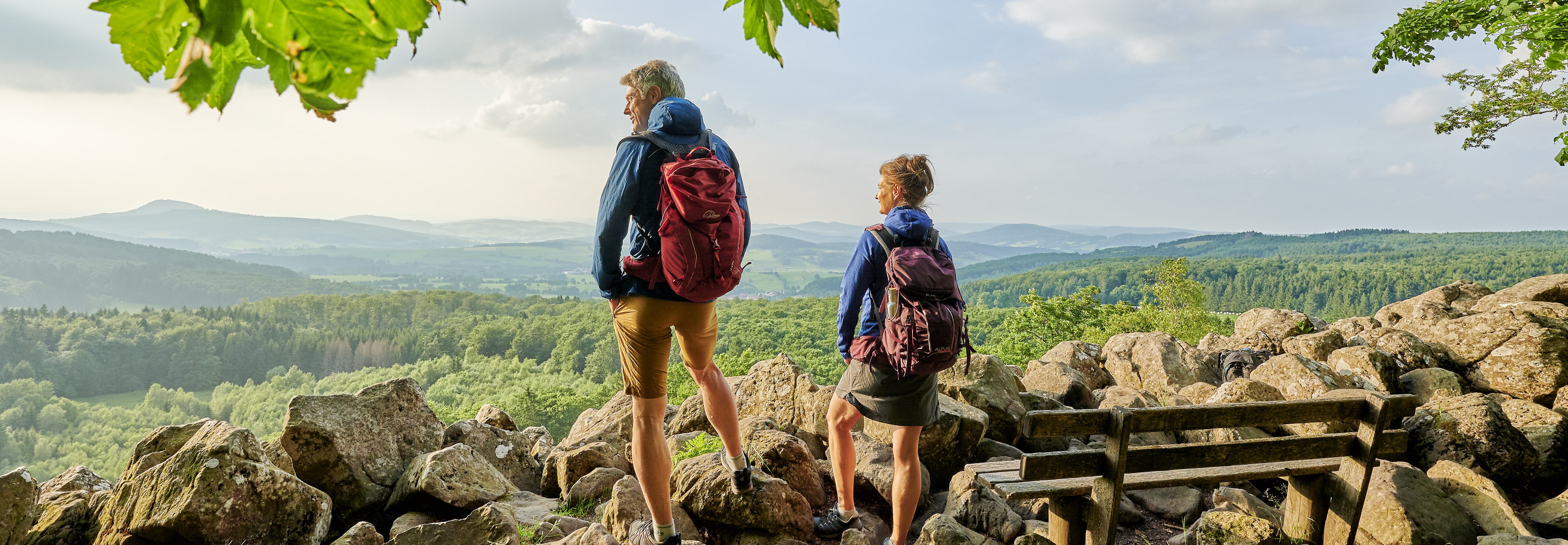 Zwei Wanderer blicken in die Ferne in der Rhön.