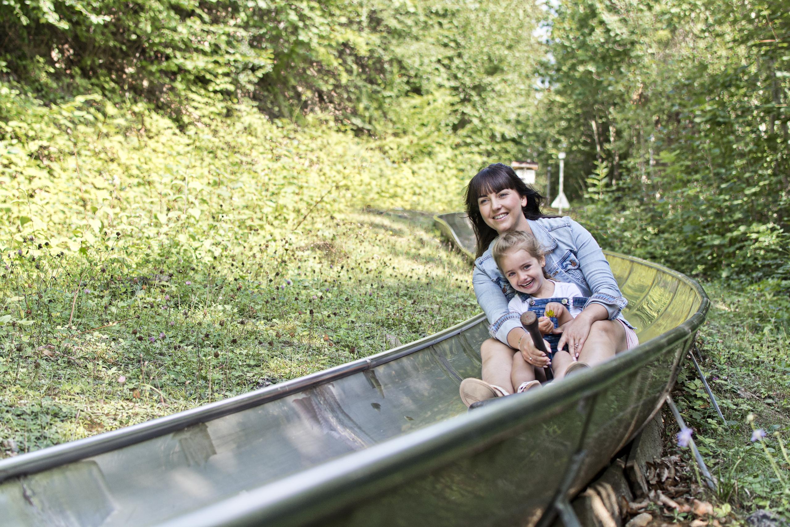 Mutter mit Kind auf der Sommerrodelbahn.