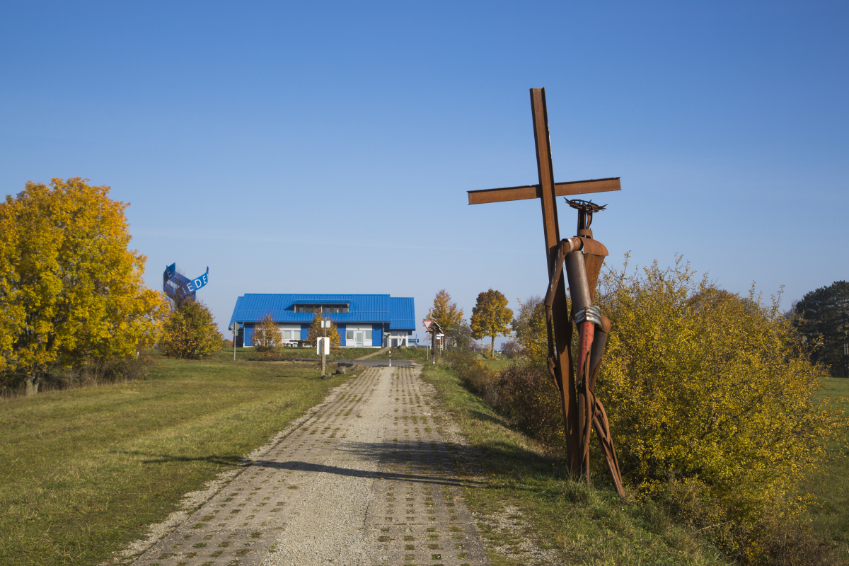 Kunstwerk auf Metall und „Haus auf der Grenze“ im Hintergrund.
