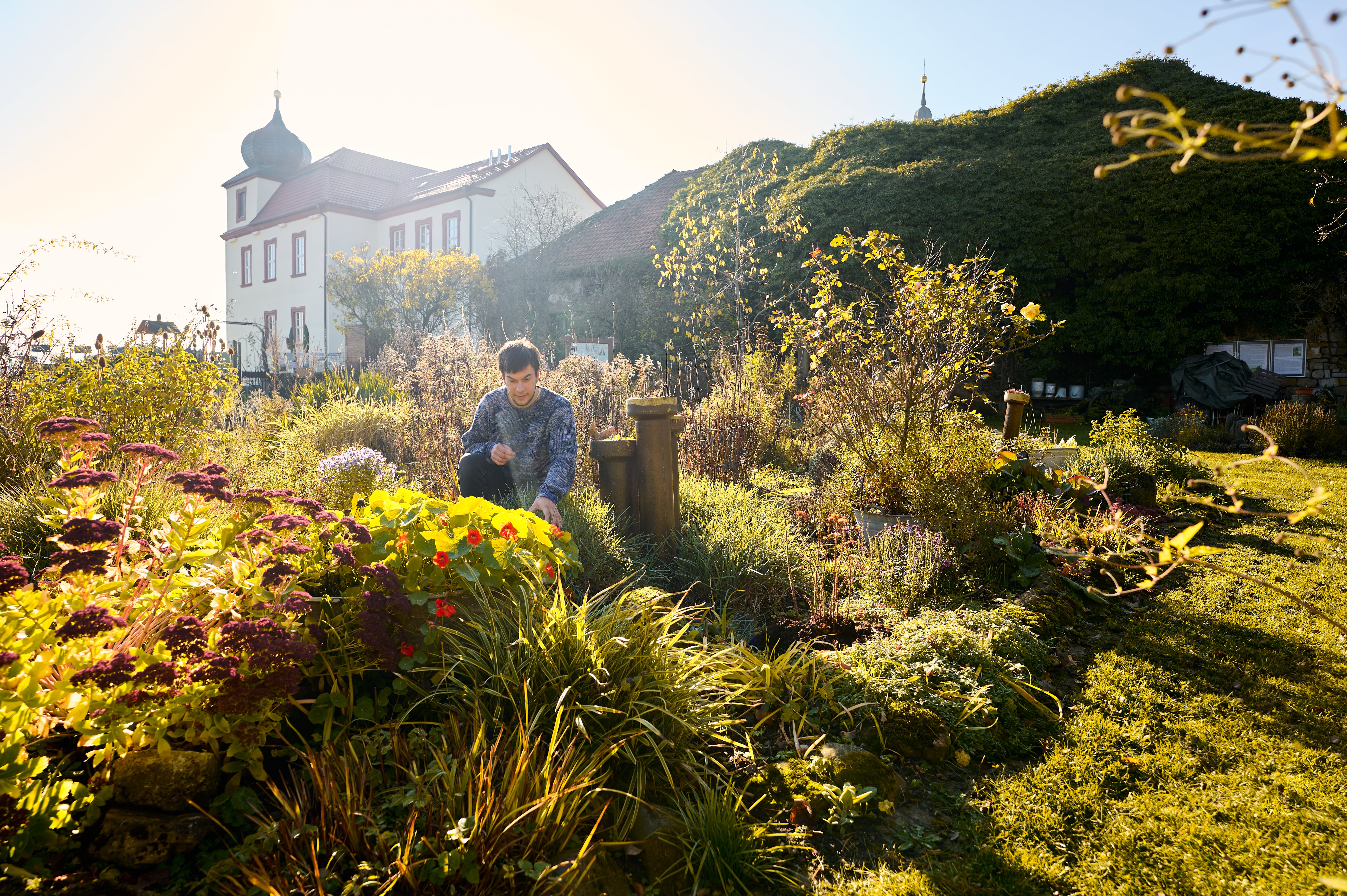 Person sitzt im Kräutergarten Zella.