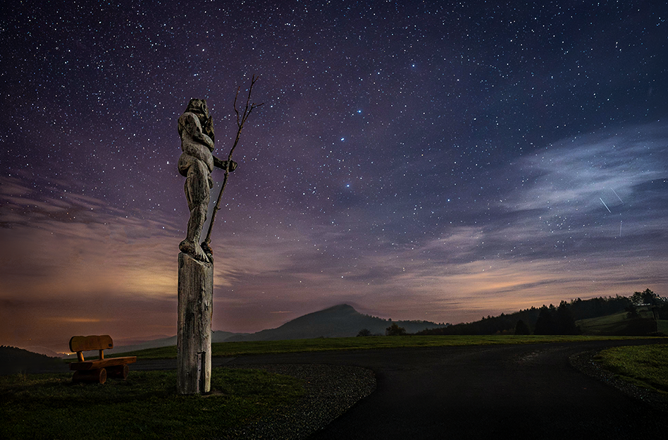 Skulptur vom Riese Mils auf der Maulkuppe mit Rhöner Sternenhimmel im Hintergrund.