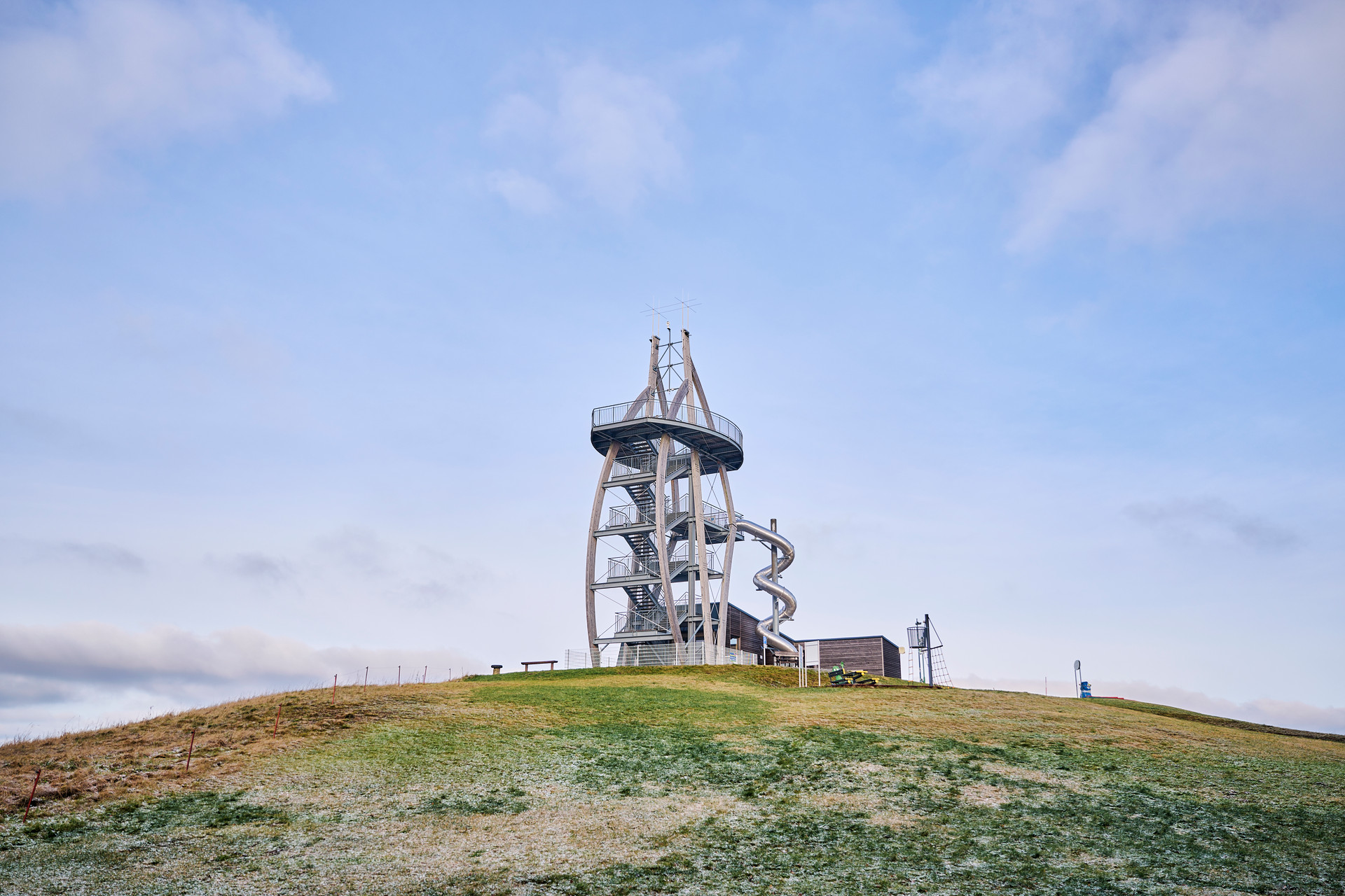 Aussichtsturm aus Metall mit Treppen und einer Metallrutsche.