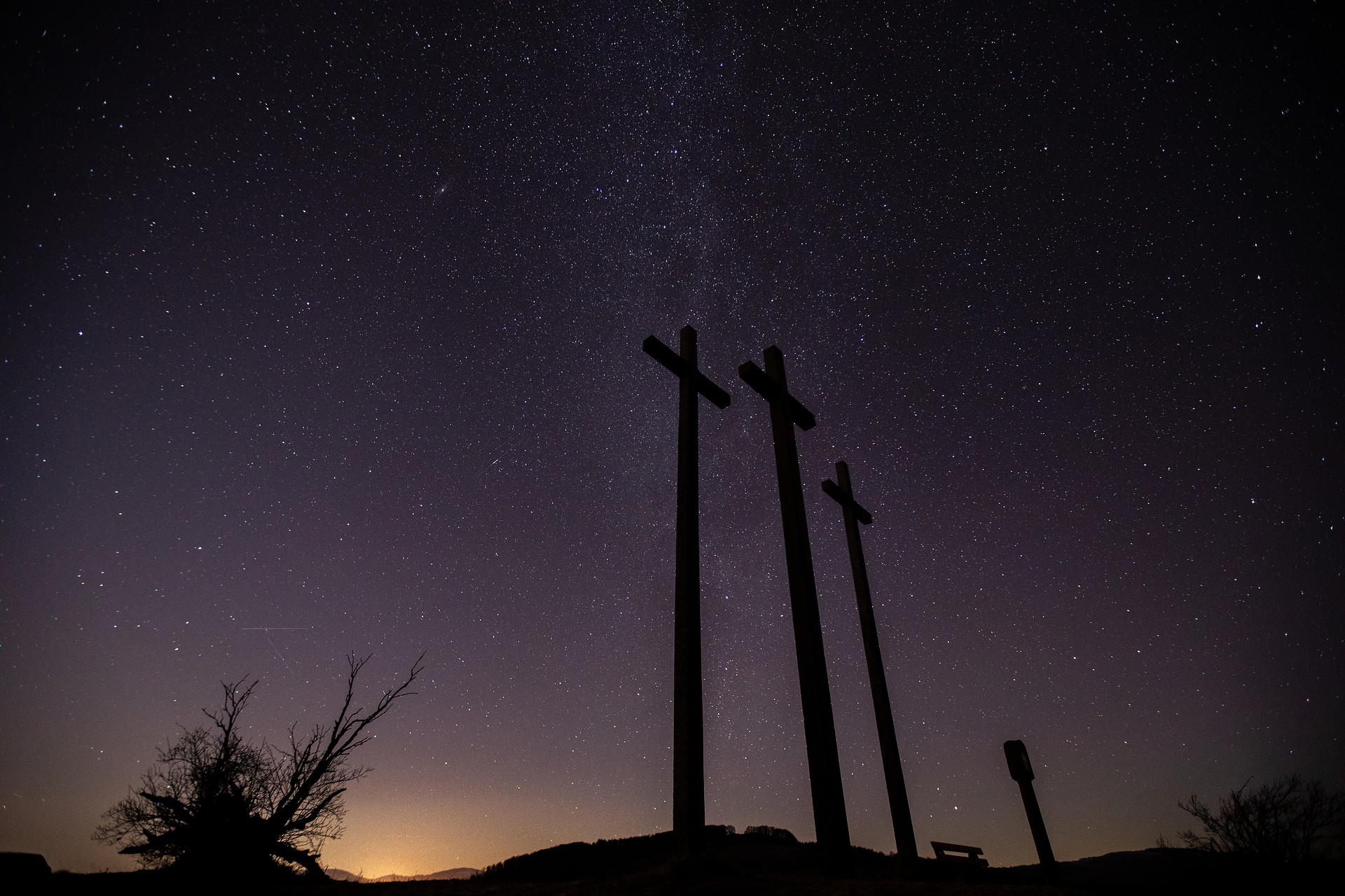 Die drei Kreuze des Kreuzberges bei Nacht mit der Milchstraße am Himmel.