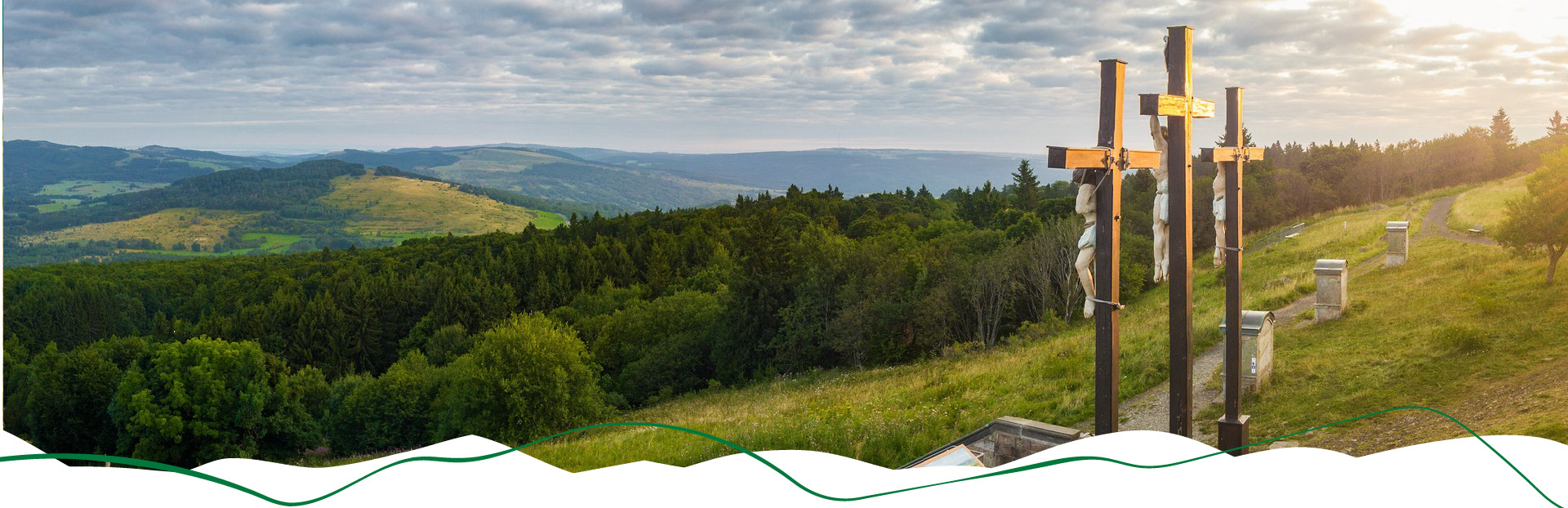 Blick vom Kreuzberg in die Rhön mit den drei Kreuzen im Vordergrund.